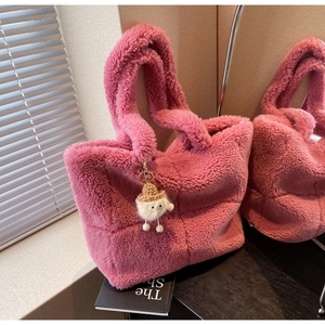Rosa Teddy-Stoff Tasche Detail mit weicher Textur und süßem Bommel-Anhänger mit Hut