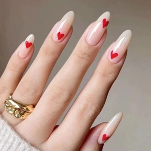 Minimalist almond press-on nails with nude base and red heart French tips for women