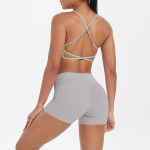 Vue arrière du soutien-gorge de sport gris clair à bretelles croisées et short de fitness