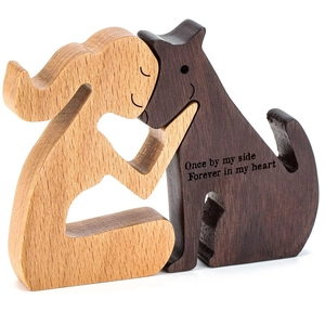 Handcrafted wooden sculpture of human and dog hugging with memorial heart engraving