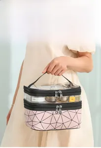 Close-up of double-layer travel makeup bag with clear PVC top and pink geometric patterns
