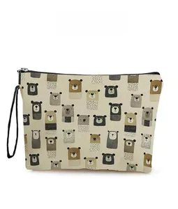 Detail of beige canvas bear pouch featuring cartoon prints and black zipper handle strap