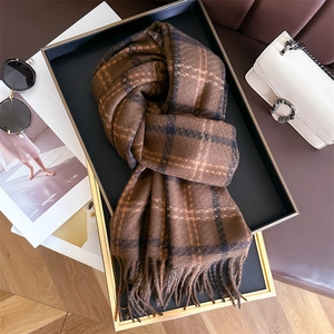 Brown plaid cashmere-like scarf with tassels displayed on a luxury tray in a lifestyle setting