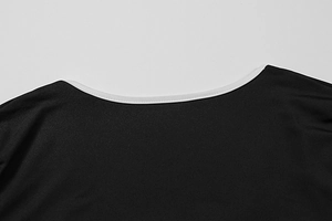 Detailed close-up of a black top neckline featuring clean white piped edges and knit texture