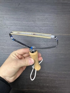 Detail of manual lint remover with dual copper blades, steel frame and ergonomic wood handle