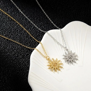 Detailed close-up of sunburst necklaces in gold and silver over textured background