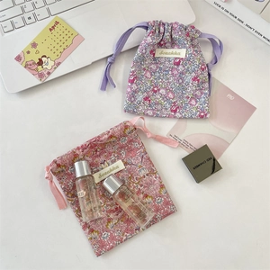 Pochettes à cordon fleuries avec papeterie et soins sur un bureau lumineux