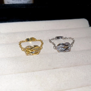 Macro shot of gold and silver knot chain rings with pave zircon on velvet box