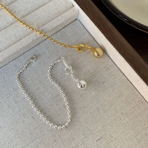 Detail of minimalist S925 silver beaded knot bracelets in gold and silver finishes