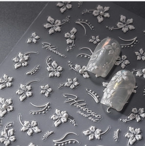 Macro view of 5D white hibiscus nail stickers with embossed 3D texture and pearl details