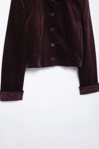 Détail de la veste courte en velours violet foncé avec boutons noirs et poignets