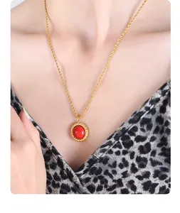 Close-up of gold twist chain necklace featuring a vintage round red agate pendant on a model