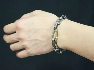 Detailed view of silver titanium steel thick chain bracelet with engraved pattern on wrist