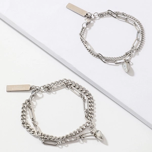 Close-up of magnetic heart-shaped charms on silver-toned Cuban link couple bracelets
