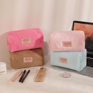 Close-up of colorful plush makeup bags with zipper and label in a lifestyle setting