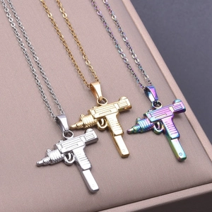 Detailed macro view of Uzi gun shaped pendants in gold, silver, and rainbow finishes