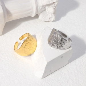 Macro detail of gold and silver queen relief rings with hammered texture on white stone