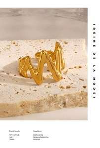 Detail of 18K gold plated wavy ring with organic molten texture on stone base