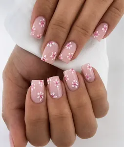 Close-up detail of stylish pink floral press-on nails in a short square manicure design