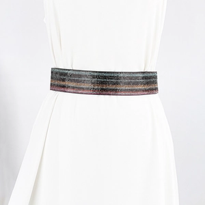 Macro detail of elastic wide cinch belt with colorful rhinestone stripes for evening dresses