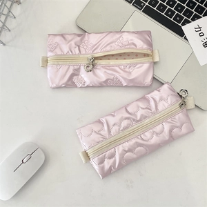 Detail of pink quilted pencil cases with heart and bow patterns and flower zip pulls