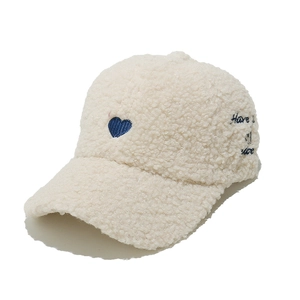 Close-up of blue heart embroidery on cream white sherpa fleece baseball cap