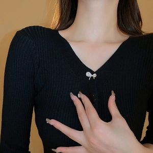 Élégante broche nœud en zircon avec cristaux étincelants sur un pull en maille noir