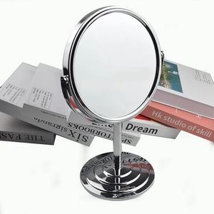 Detail of round double-sided metal makeup mirror with 1:2 zoom on polished chrome base