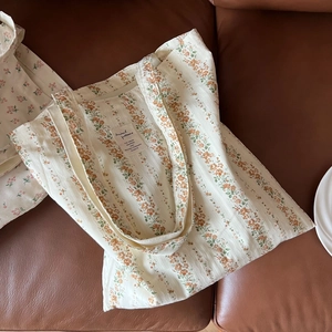 Detail of floral canvas tote bag with animal pattern on a brown leather sofa
