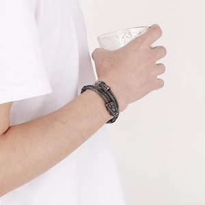 Detailed view of punk style double wire dragon head bracelet worn on a male wrist