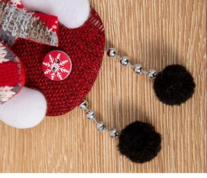 Detail of Christmas plush doll with snowflake button, bead legs, and soft knit texture