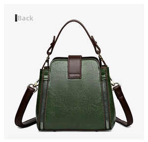Rear view of dark green pebbled leather bucket bag with brown straps and gold hardware