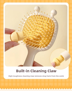 Detail showing the built-in hair cleaning tool on the yellow massage air cushion brush