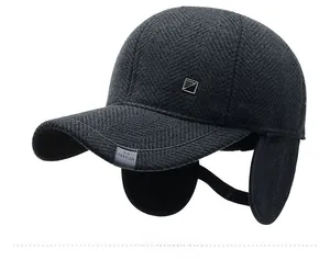 Detail of grey herringbone wool baseball cap featuring ear flaps and side metal logo