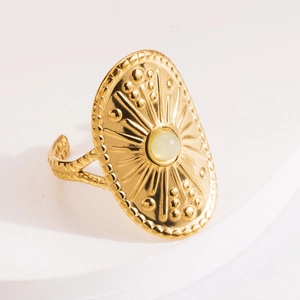 Close-up of vintage adjustable gold ring featuring sunburst relief and green stone inlay