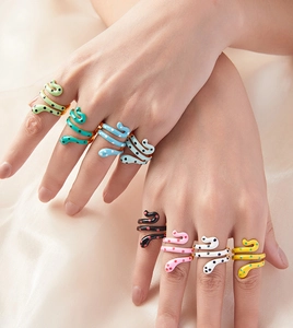 Detailed view of eight colorful enamel snake rings with gold plating on model hands