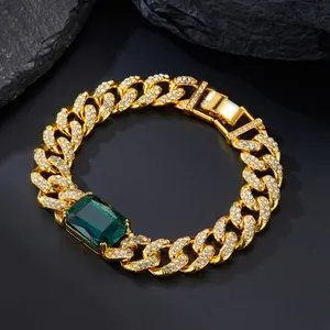 Dettaglio della catena cubana dorata con pietra verde taglio smeraldo e strass luminosi