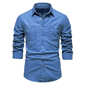 Detailed view of long sleeve denim shirt featuring dual chest pockets on white backdrop