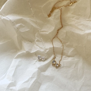 Macro detail of gold and silver heart zircon pendants on elegant thin O-chains