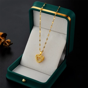 Golden heart necklace with dancing stone pendant in a green luxury jewelry gift box