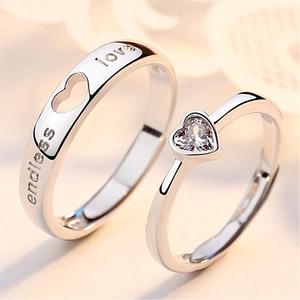 Close-up of couples rings with heart-shaped stone and Endless Love engraving