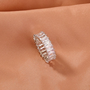 Close-up of silver ring with full circle baguette cut cubic zirconia on orange satin