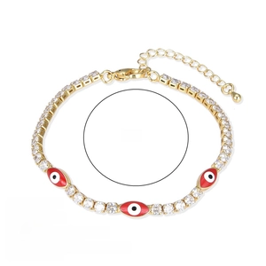 Close-up of gold evil eye bracelet with white zircon squares and red enamel pendants