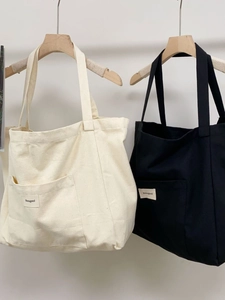 Large striped canvas tote bag set in cream and black with stylish wide shoulder straps