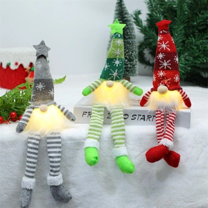 Three glowing Christmas gnomes with knit hats and long dangling legs in festive colors