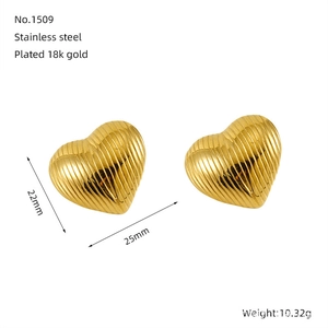 Détail macro des boucles d'oreilles cœur en acier inoxydable plaqué or 18 carats texturé