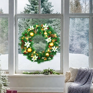 Detail of Christmas wreath with gold baubles, pine cones, and red berries on a festive background