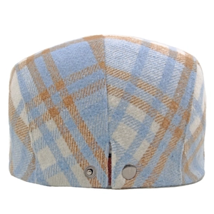 Close-up of blue and brown plaid wool newsboy cap showing fabric texture and metal buttons