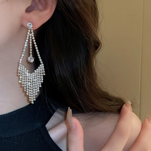 Close-up of sparkling long tassel earrings with silver needles and luxury cubic zirconia