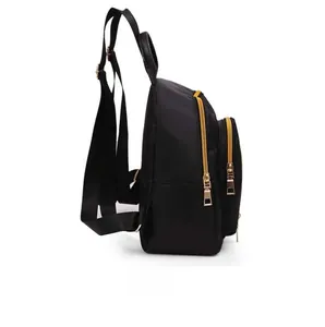 Side view of sleek black waterproof nylon backpack featuring polished gold zippers and straps